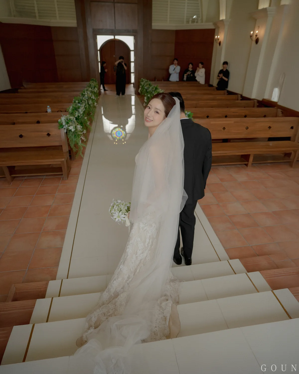 예식장 계단에서 뒤돌아 미소 짓는 신부